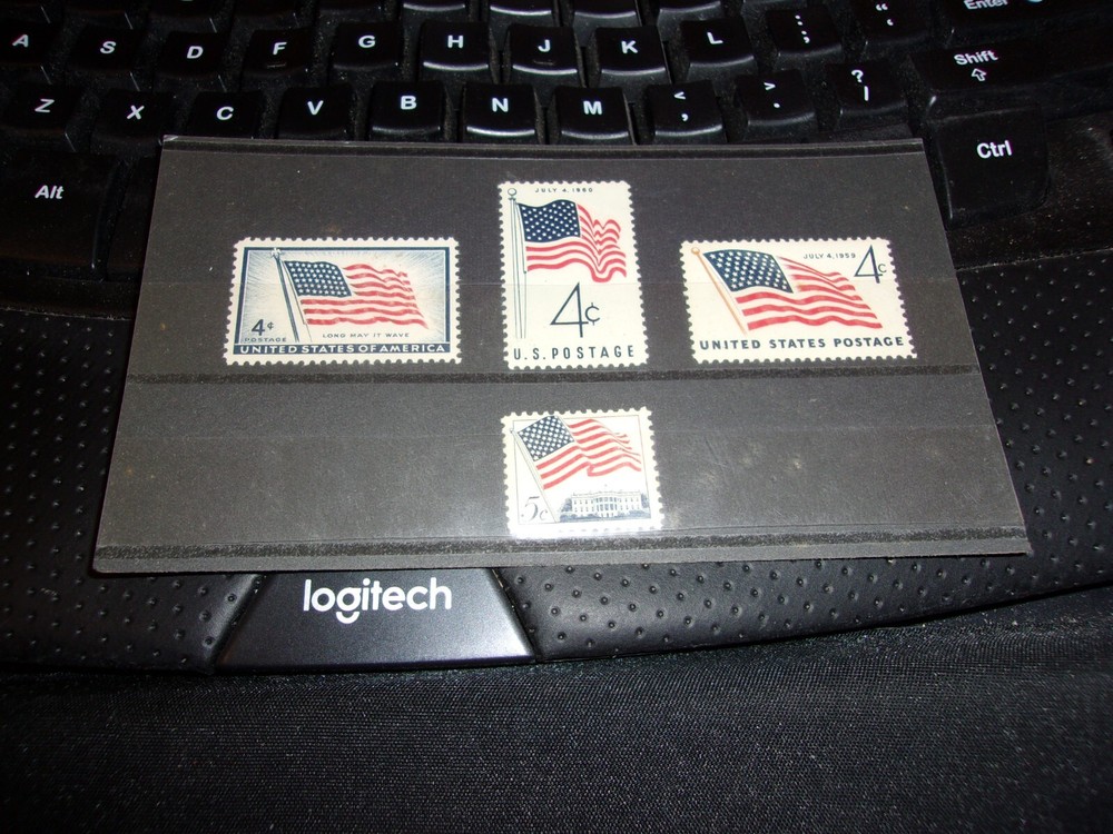 Four American Flag Stamps, 3 are 4 cent and 1 is 5 cent stamp In display folder