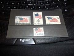 Four American Flag Stamps, 3 are 4 cent and 1 is 5 cent stamp In display folder